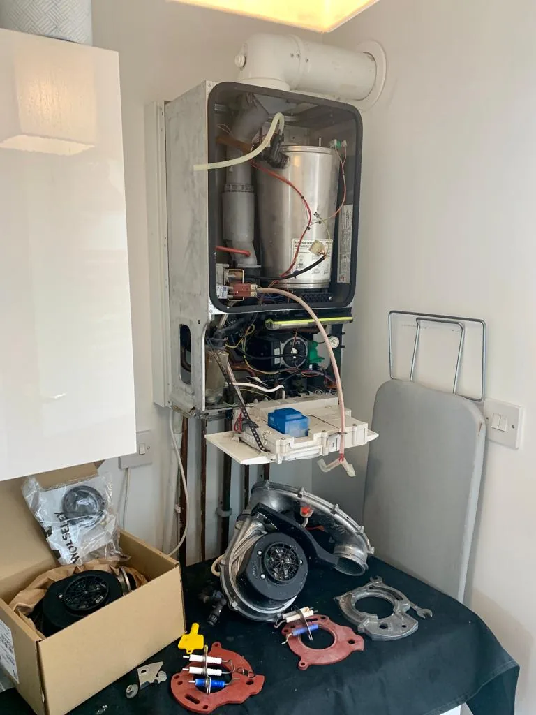 A boiler opened up with its components exposed during a service